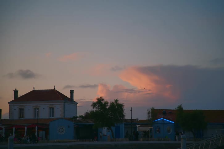 People walking through a square at dusk
