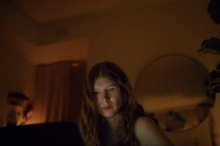 Woman sitting and interacting with a laptop in a room of the house
