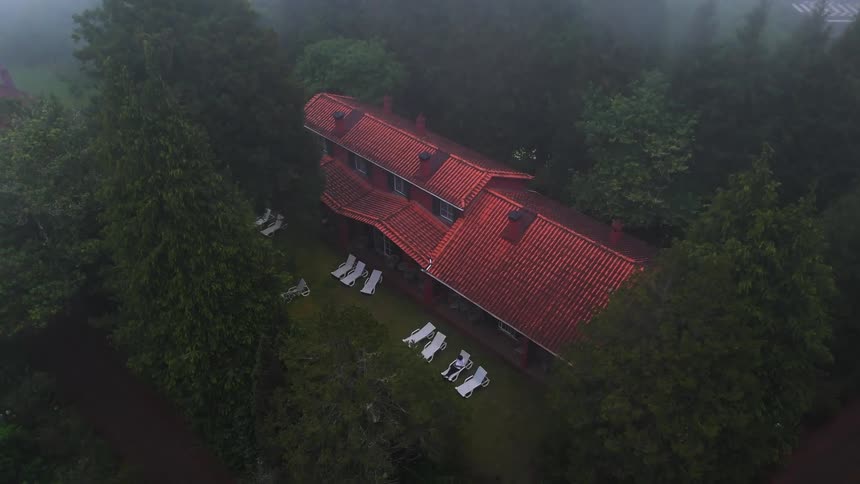 The person is sitting in a chair in the cabin yard