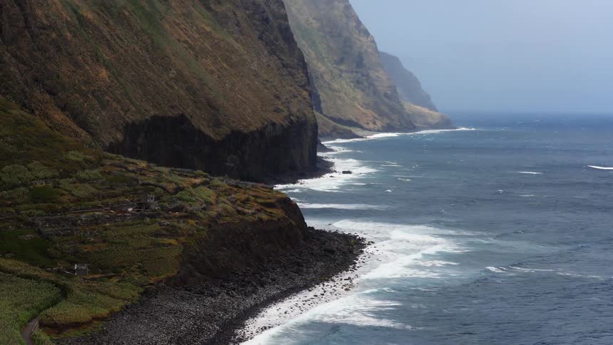 Coastal area with the sea next to a cliff where houses are located outdoors during day time