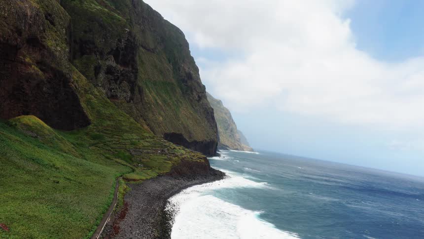 Sea waves crashing at the coast next to a cliff outdoors during day time