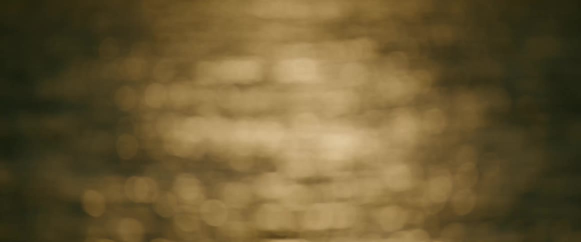 Close up of the surface of a flowing body of water outdoors at sunset