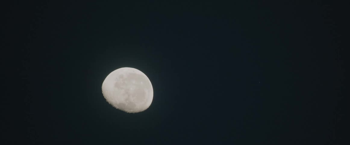 The moon glows in the night sky