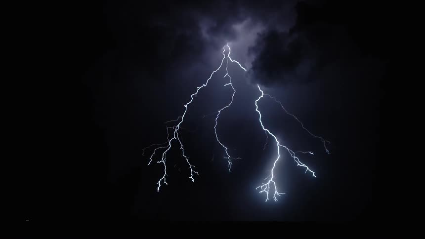 Lightning flashes and illuminates clouds as it strikes the ground