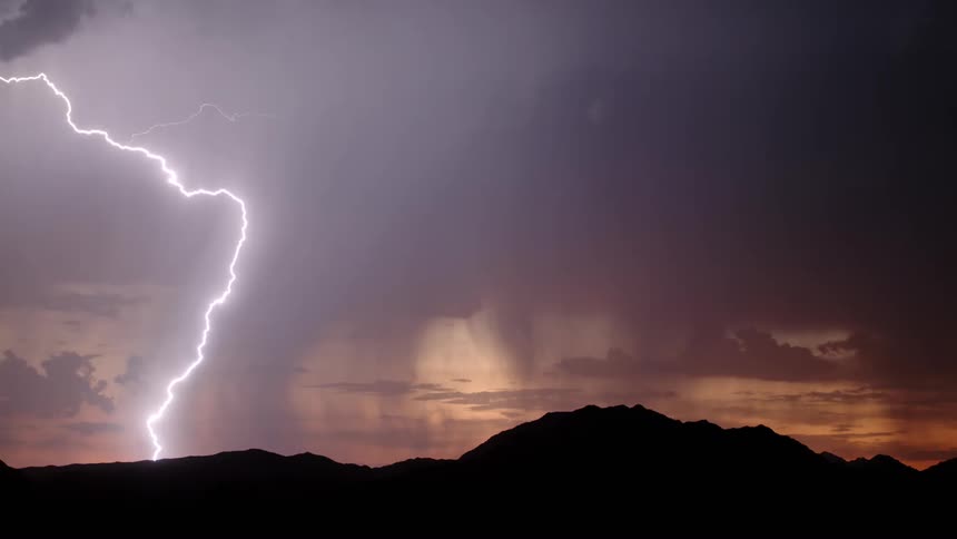 Silhouette of mountains with bursts of thunder from a storm