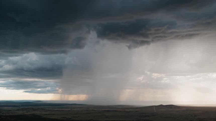 Super cell storm pours rain across the land as lighting strikes the ground