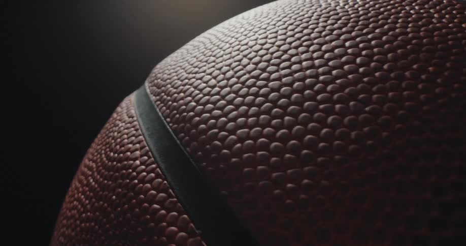 Closeup of a basketball highlighting its grainy texture and central stripe