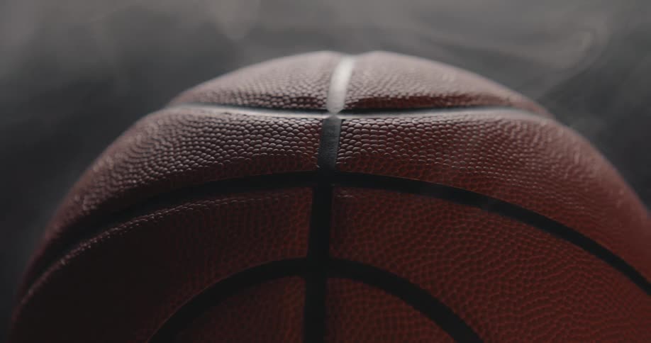 Basketball ball in closeup with visible texture and surrounding steam