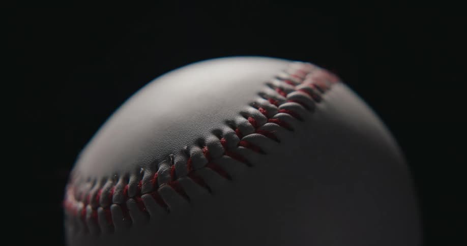 The light is moving over the top of the baseball and is causing places of shadow and light