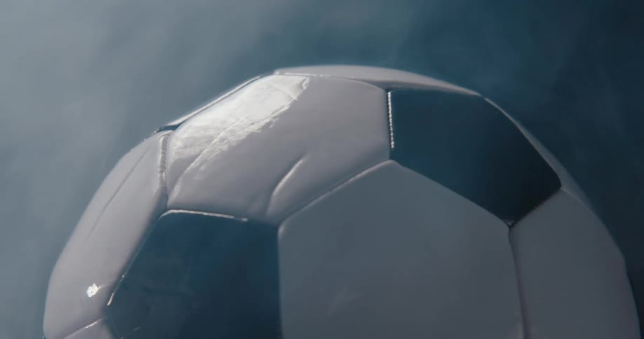 Football spinning indoors surrounded by smoke