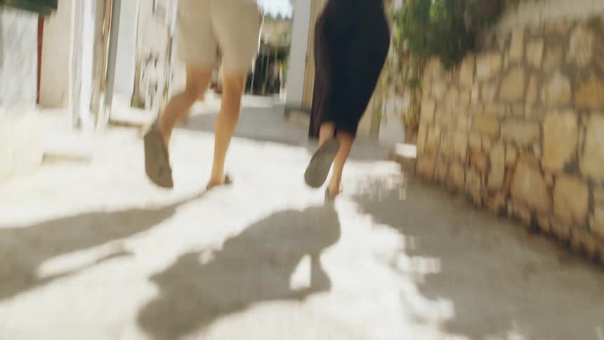 A man and woman run down a street together