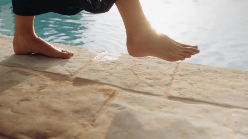 A person walking along a pool