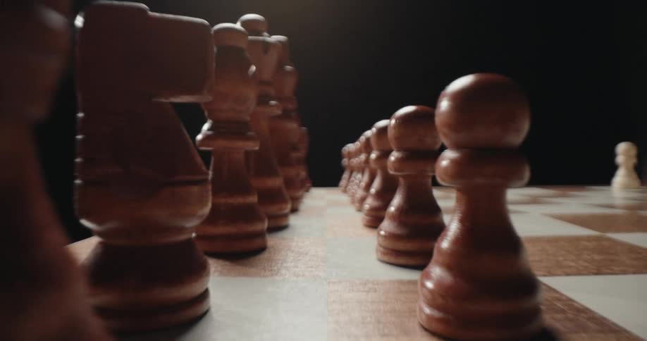 Wooden chess pieces over a wooden chessboard indoors during day time