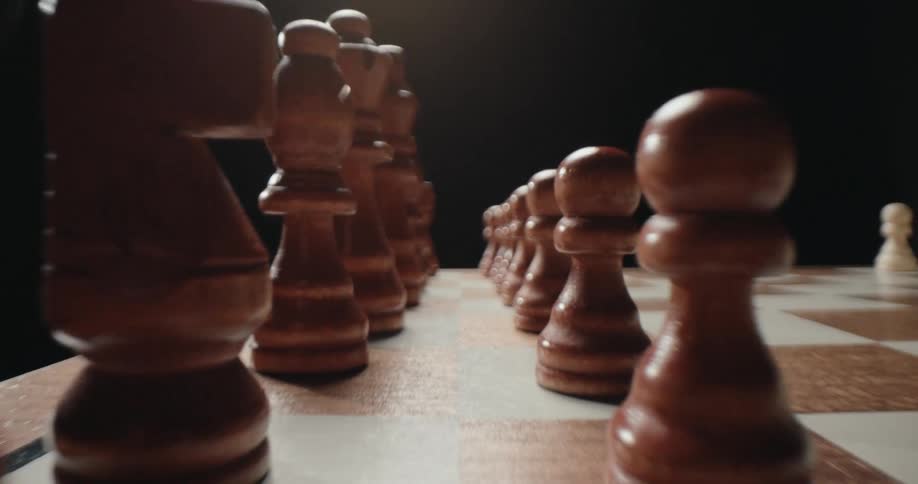 Close up of brown chess pieces arranged on a chess board