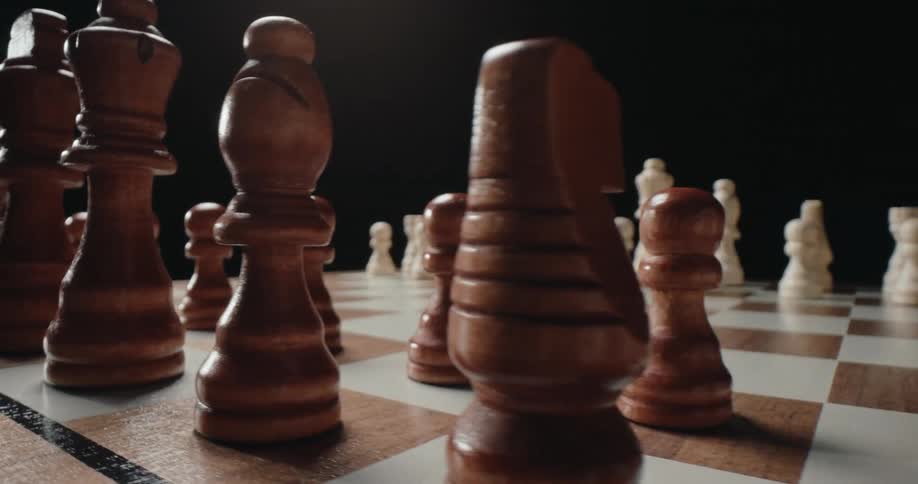 Wooden chess pieces positioned on a checkered board with shallow depth of field