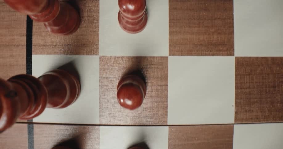 A topdown shot shows a wooden chess board as the camera slides across it capturing brown pawns a rook and a knight