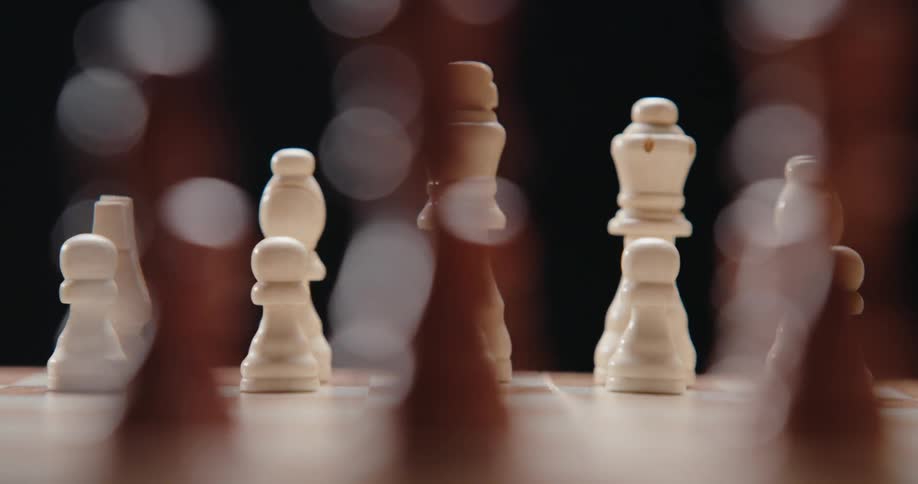 White pieces arranged on chessboard with blurred background