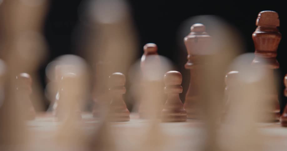 A chessboard with all the pieces neatly arranged illuminated by a bright light that reveals the details of each piece across the board
