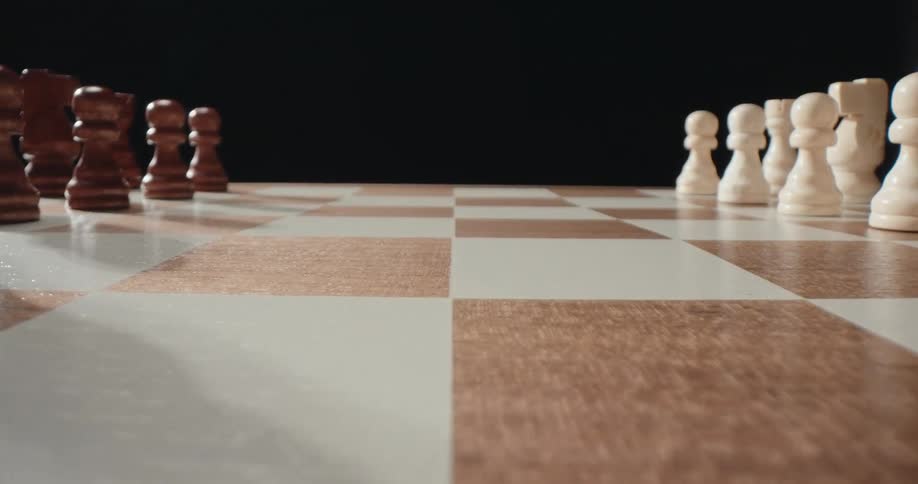 Close up of arranged brown and white chess pieces on a chess board