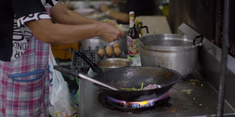 Woman cooks at a stove
