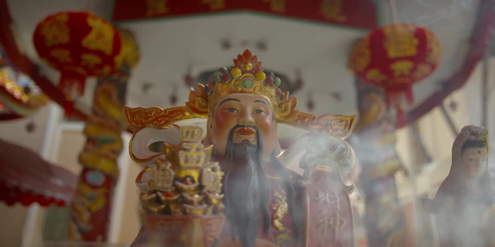 Incense smoke billows around a statue