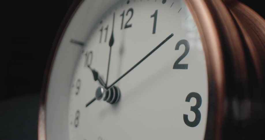 Analog clock vibrates as a small hammer hits the bells while the alarm rings