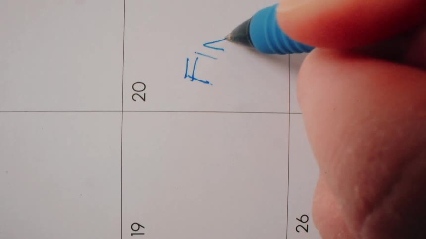 Hand writes on the 20th of a calendar