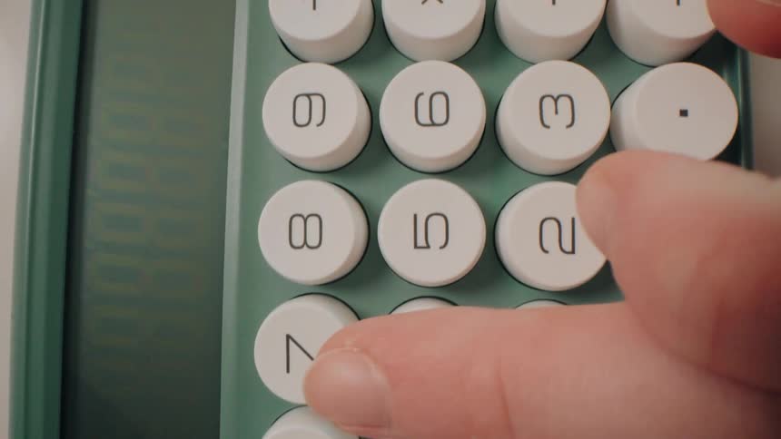 Fingers typing on a calculator