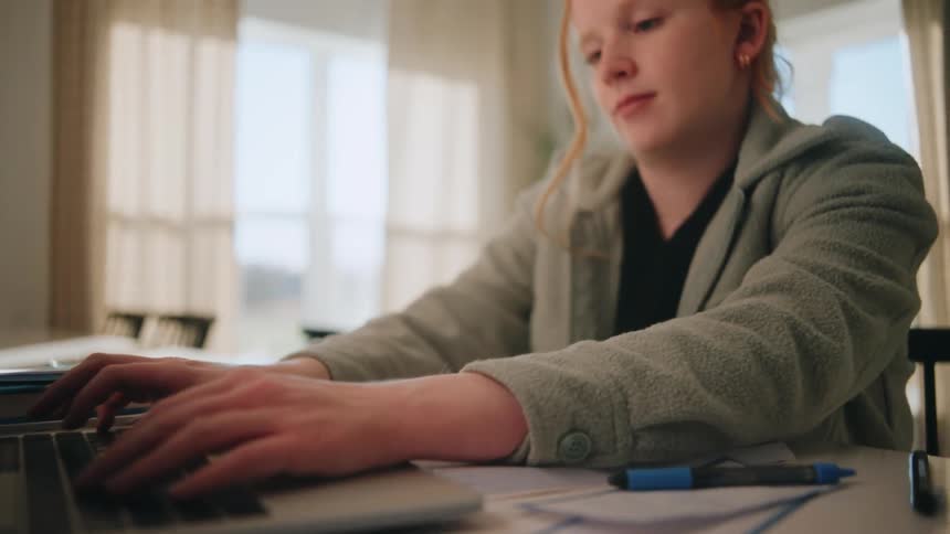 A woman typing on a laptop