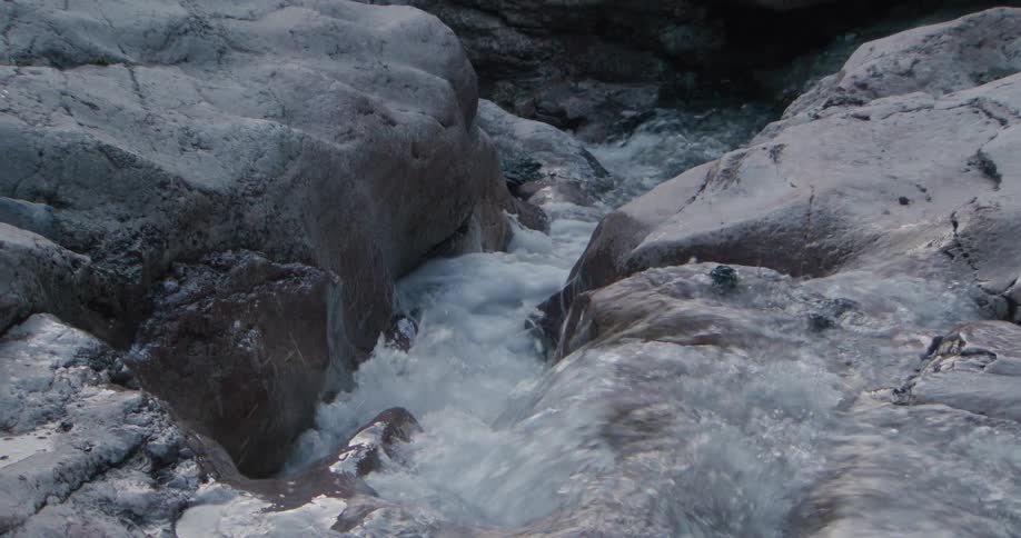 A water stream flowing between rock formations outdoors during daytime