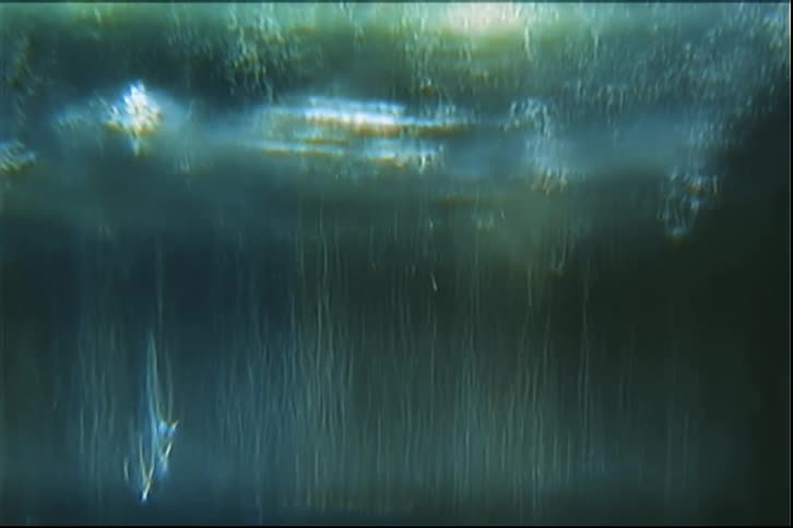 Water surface with diffuse light reflections and vertical textures created by flowing streaks