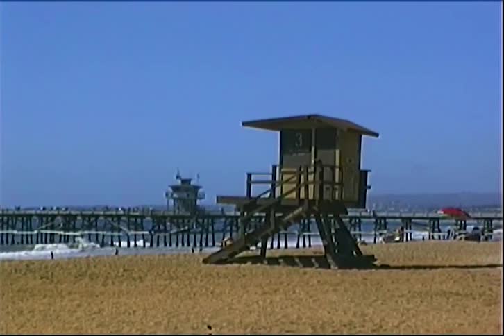 Lifeguard tower number 3 on sunny beach with wooden pier in the background