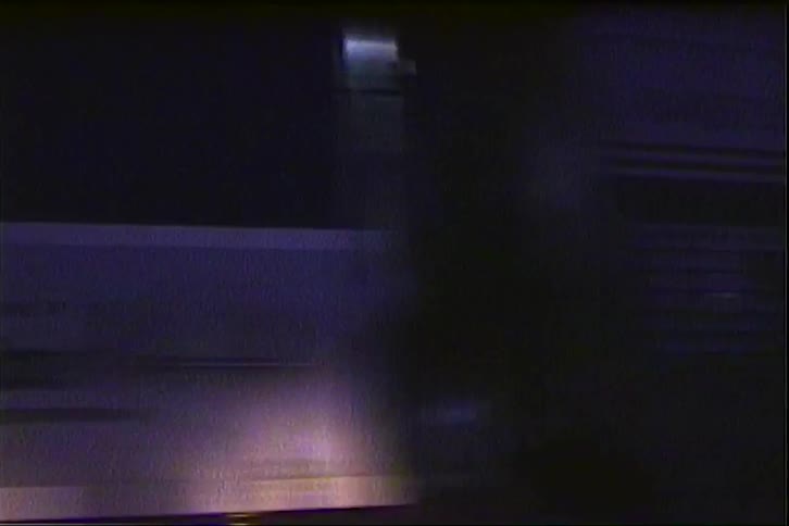 A train moving through a lit subway at night