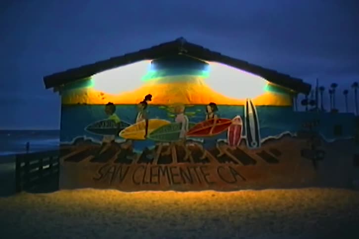 Concrete structure with artistic design illuminated at night on the beach sand