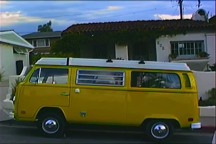 An old van sitting outdoors in front of a house