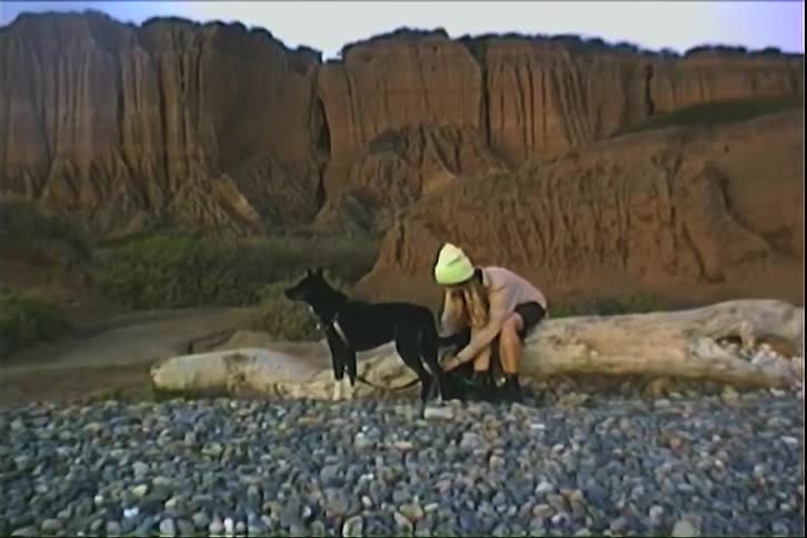 Woman sitting next to a dog in a mountain setting