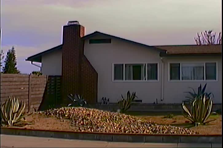 Exterior of a single story suburban home with a brick chimney and dry landscaping