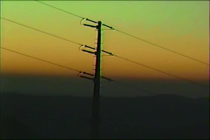 Power pole with stretched cables against a horizon showing a dusk color gradient