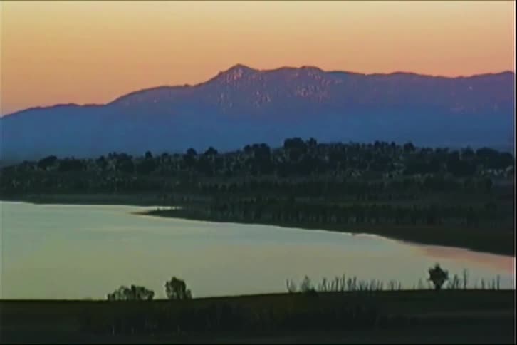 Landscape of a lake with the silhouette of mountains in the background