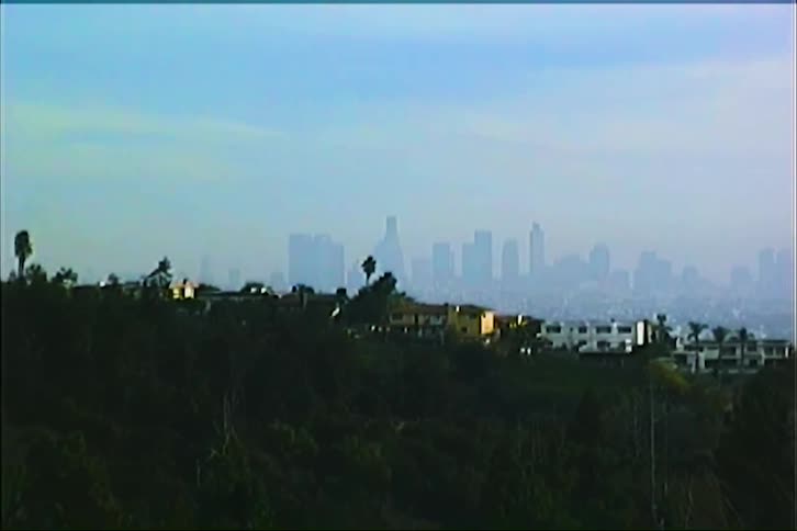 Houses in the mountains with the silhouettes of skyscrapers on the horizon