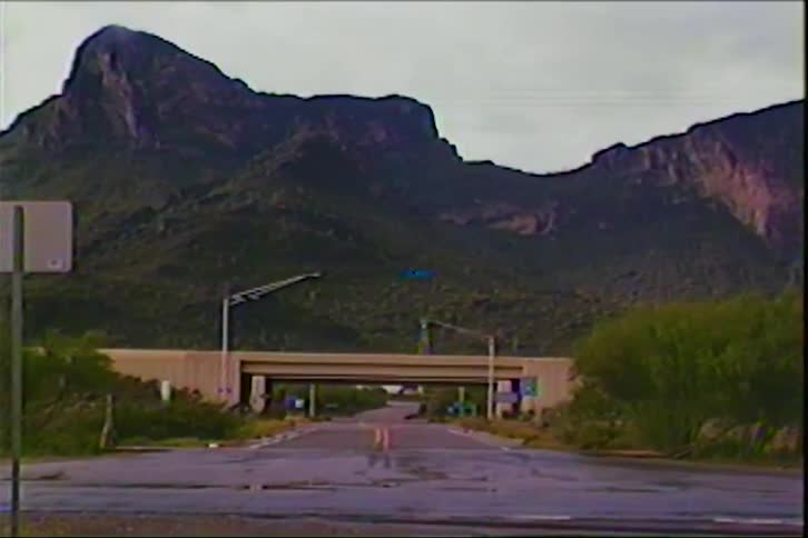 Vehicles moving on an overpass near a mountain at sunset