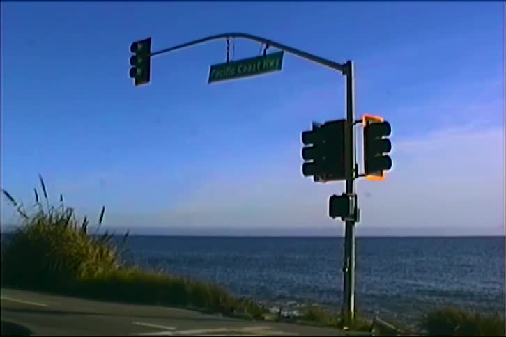 Traffic light on pacific coast hwy with ocean view under clear blue sky