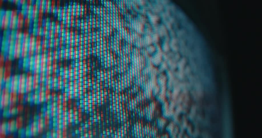In an extreme closeup the glowing red green and blue pixels of a vintage crt screen become visible as static and distorted shapes move across its surface