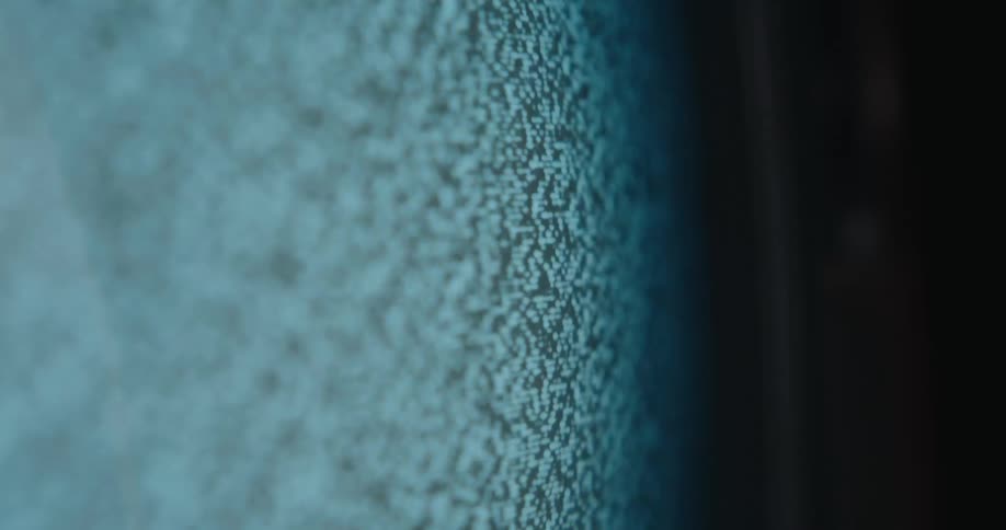 A staticfilled vintage television glowing in a dark room
