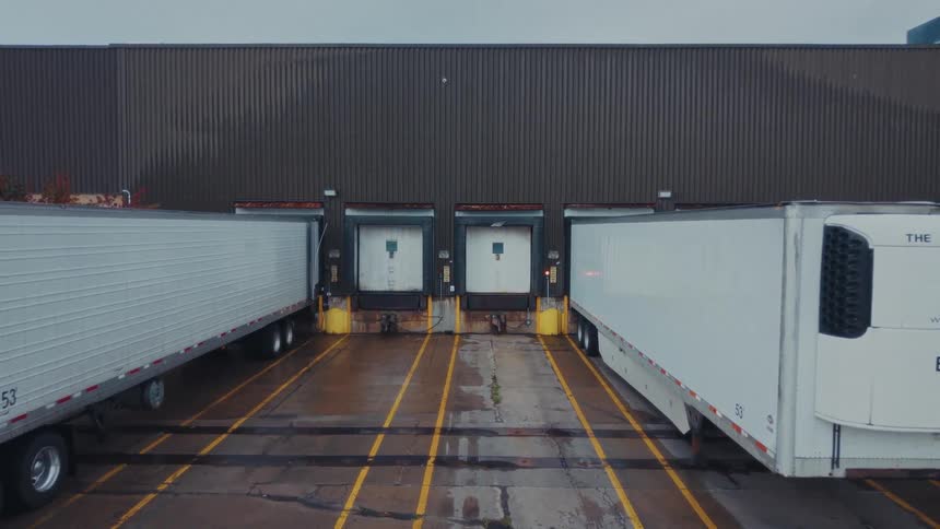 Trucks are lined up against the warehouse