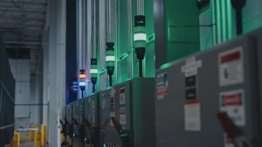 Electric control boxes are topped with colored lights in a facility