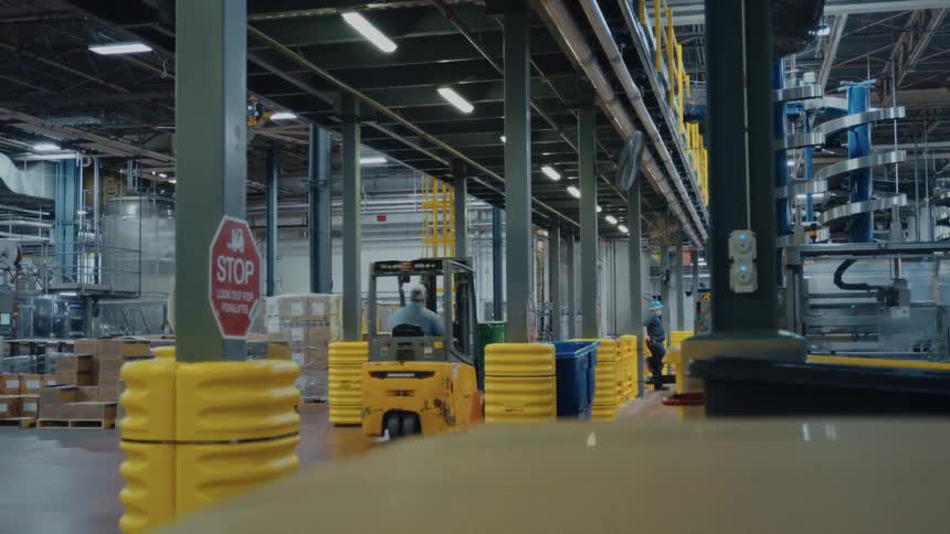 A person driving a forklift in a warehouse