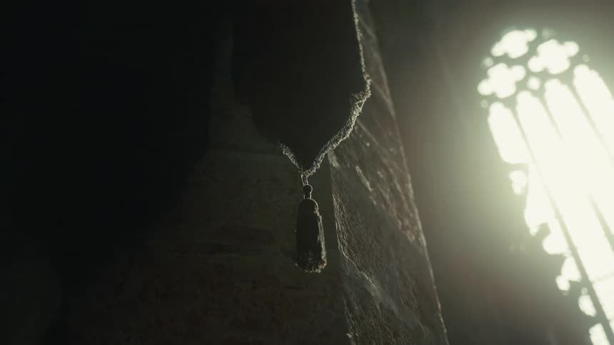 Hanging cloth draped beside a column in a gothic architectural setting