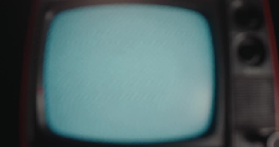 Starting with a closeup of a distorted pattern the camera pulls back to show a vintage television set its blank screen fading into a soft blur