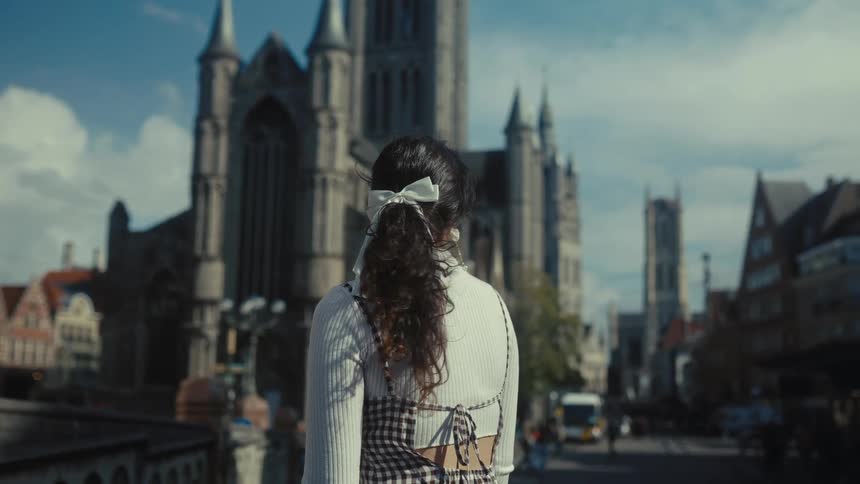 Woman outdoors observing a medieval cathedral